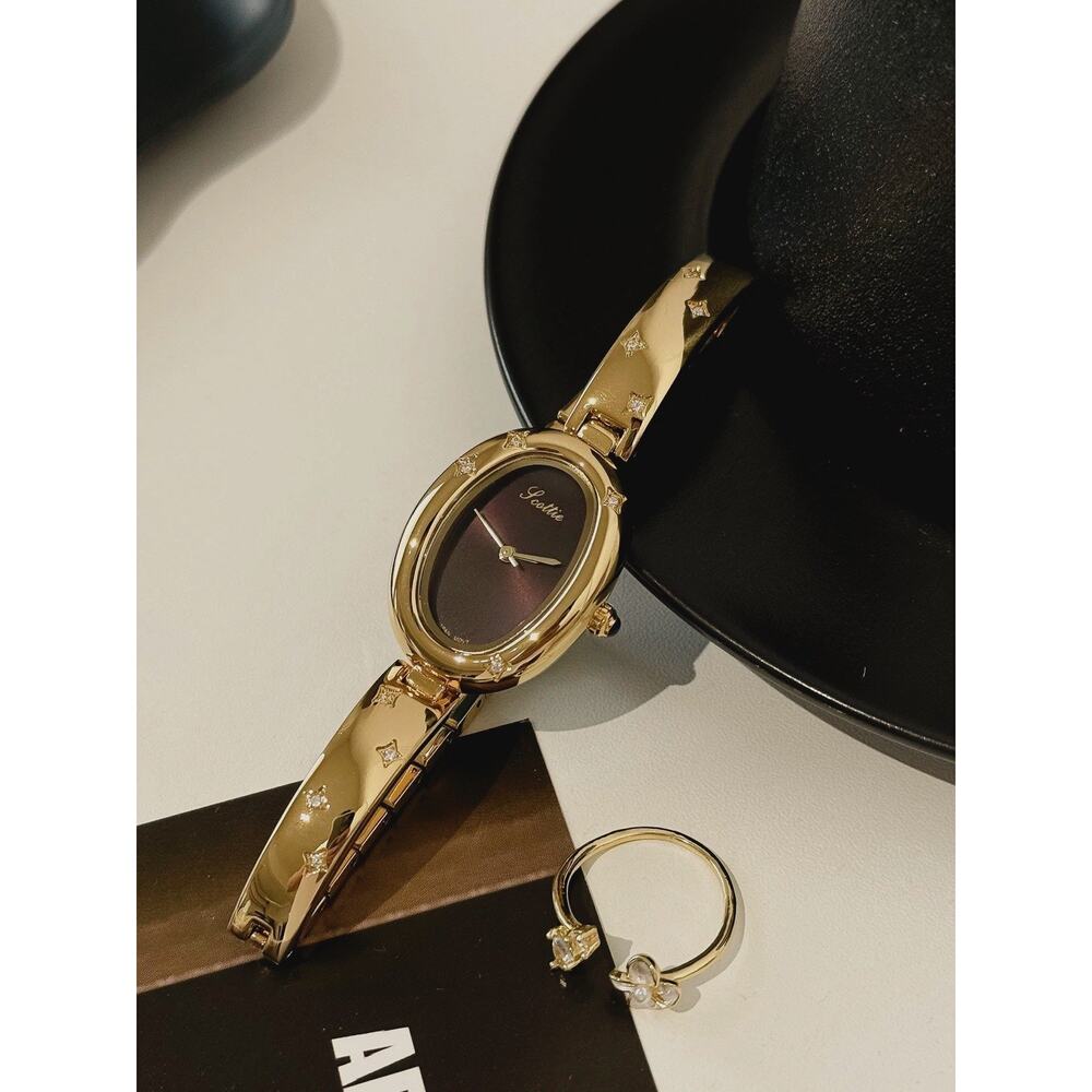 Elegant Gold Oval Ladies Luxury Watch with Dark Brown Maroon Dial & Star Accents